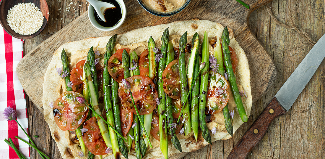 Schiacciata croccante con asparagi, pomodori e hummus di arachidi